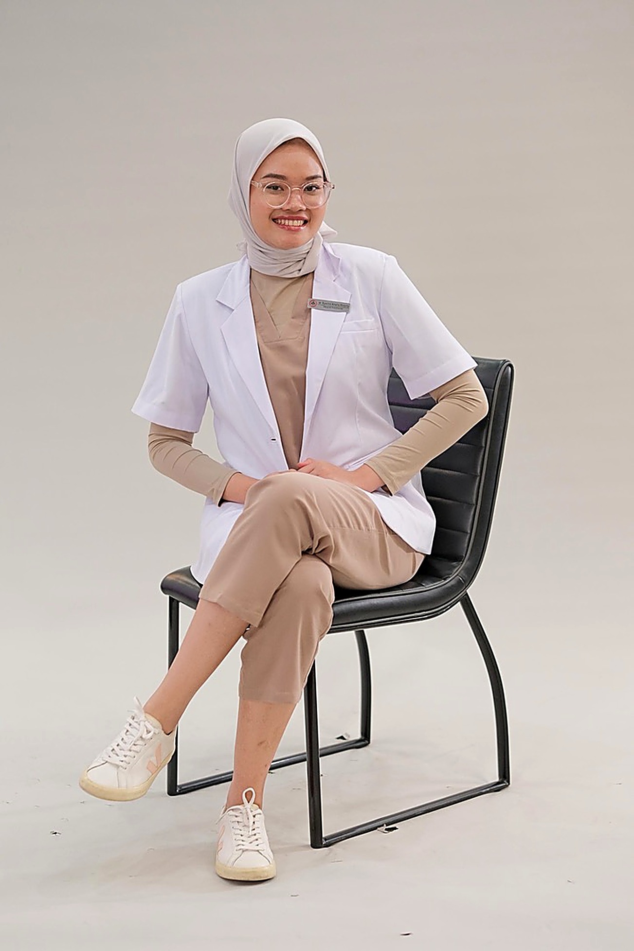dr. Syavira Amelia Risanty seated, wearing a white medical coat